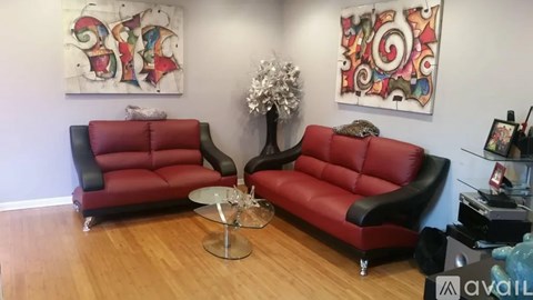 A living room with two red leather sofas and a glass coffee table.