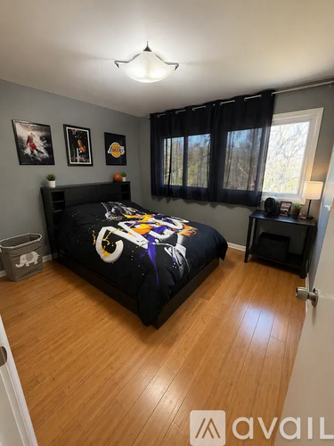 A bedroom with a black bed and a black chair.