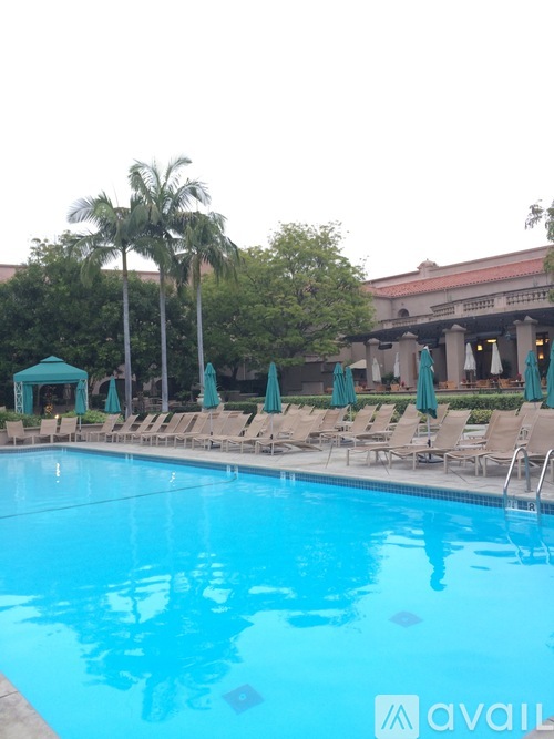 A pool with chairs and umbrellas is available for use.