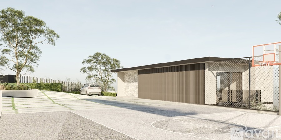 A modern building with a grey facade and a white van parked in front.