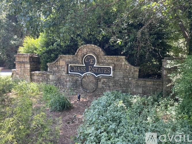 A stone wall with a Chase Estates sign in the middle of it.