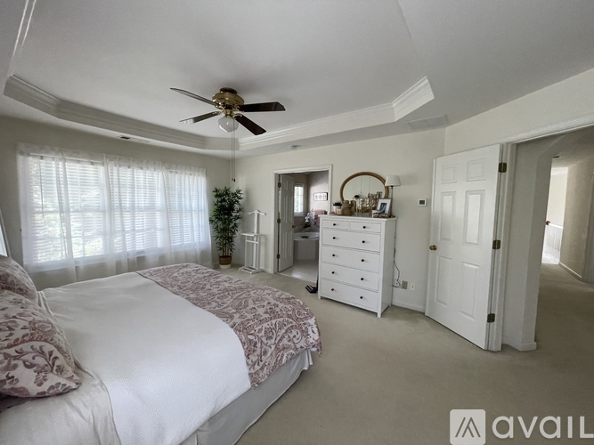 A bedroom with a large bed and a ceiling fan.