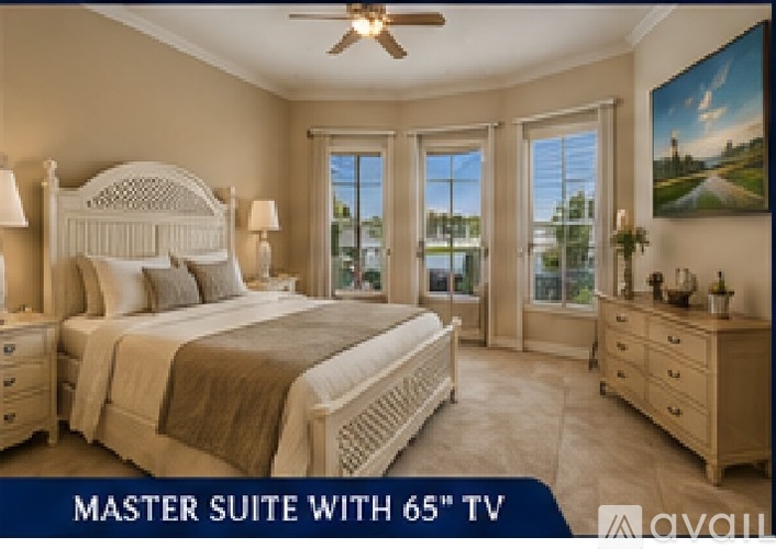 A bedroom with a large bed, a ceiling fan, and a painting on the wall.