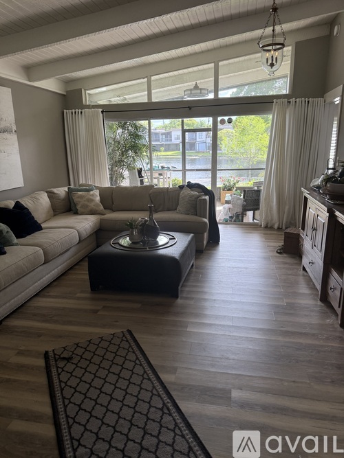 A living room with a grey sofa and a black coffee table.