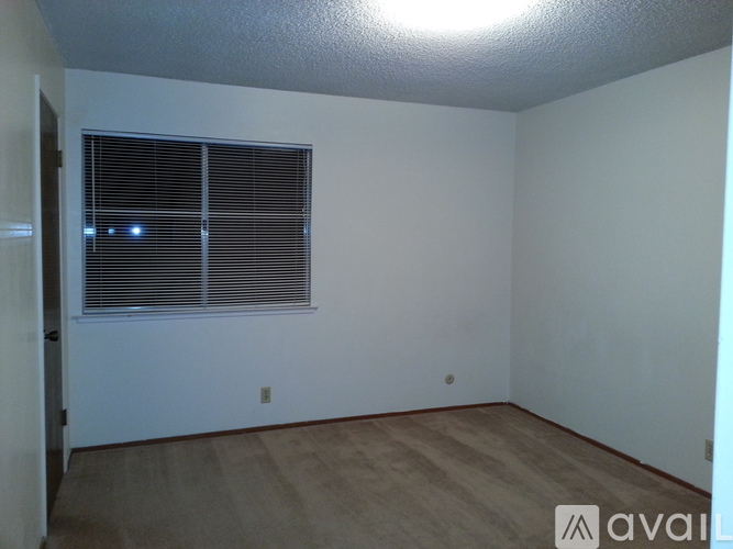 A room with a window and wooden flooring is available for rent.