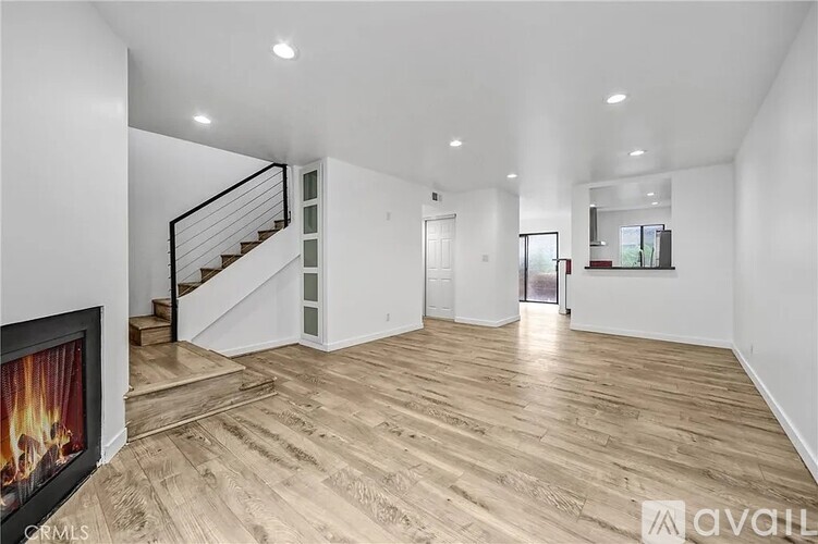 A living room with a wood floor and a staircase.