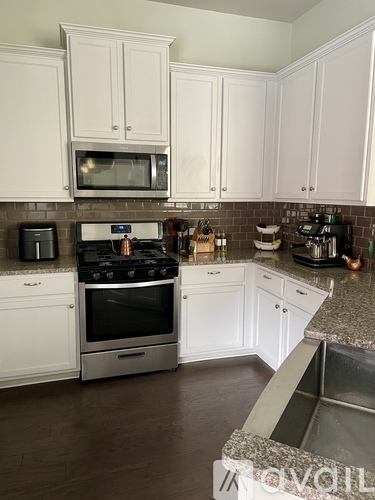 A kitchen with white cabinets and a black stove top.