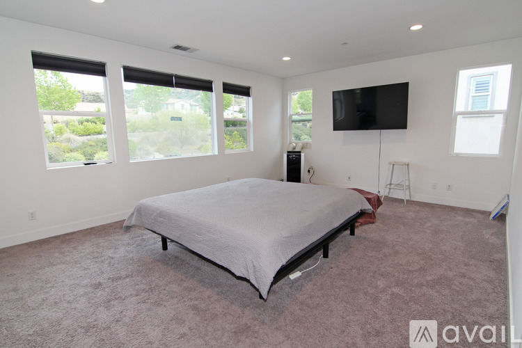 A bedroom with a large bed and a flat screen TV mounted on the wall.