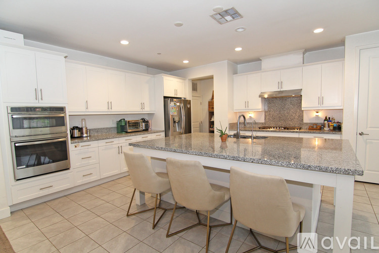 A kitchen with white cabinets and a granite countertop.