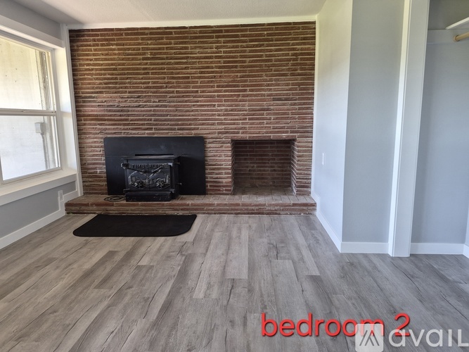 A room with a brick wall and a fireplace.