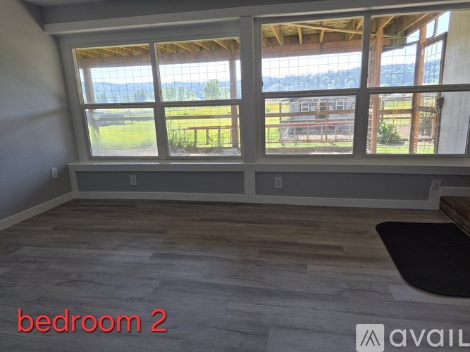 Bedroom 2 has a large window with a view of the countryside.