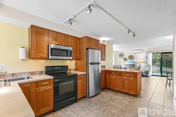 A kitchen with wooden cabinets and a black oven.