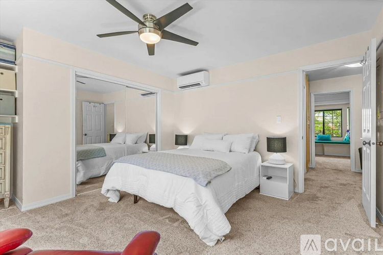A bedroom with a large bed and a ceiling fan.