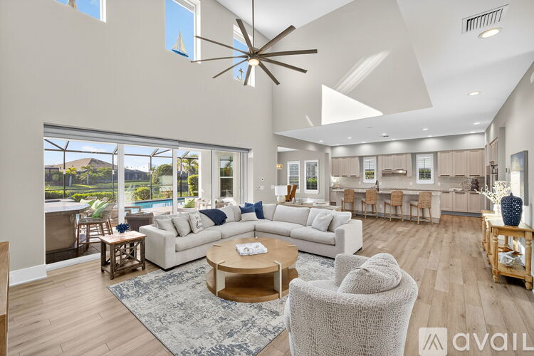 A spacious living room with a large white sofa and a wooden coffee table.