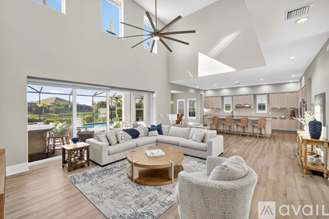 A spacious living room with a large white sofa and a wooden coffee table.