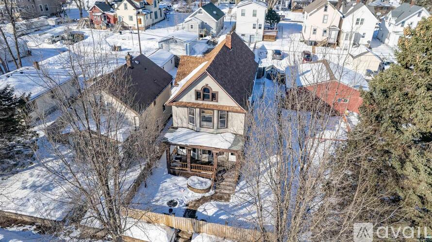 A house with a snow-covered ground and trees.