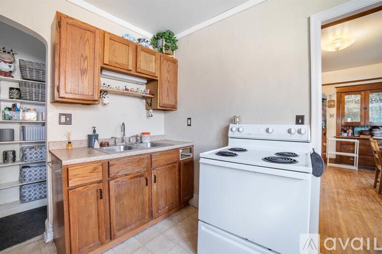 A kitchen with wooden cabinets and a white stove.