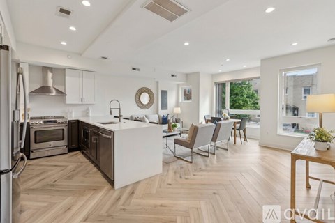 A modern kitchen with wooden flooring and a large island.