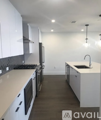 A modern kitchen with white cabinets and a black stove top.