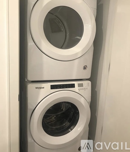 Two Whirlpool washing machines stacked on top of each other.