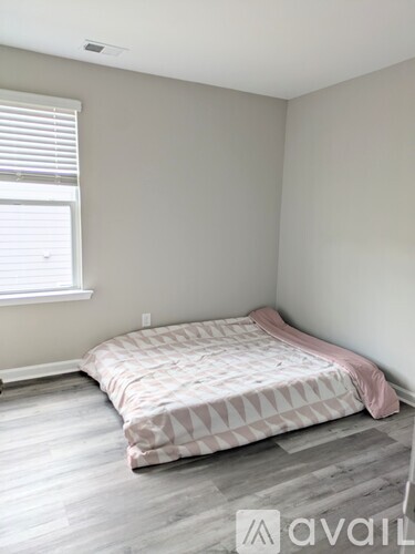 A bedroom with a bed and a window.