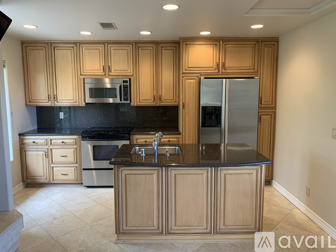 A kitchen with wooden cabinets and a black countertop.