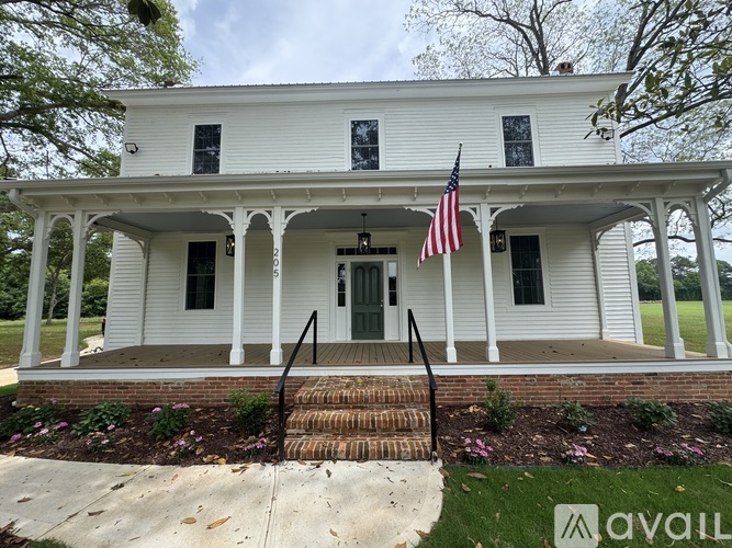 A white house with a flag on the front porch.