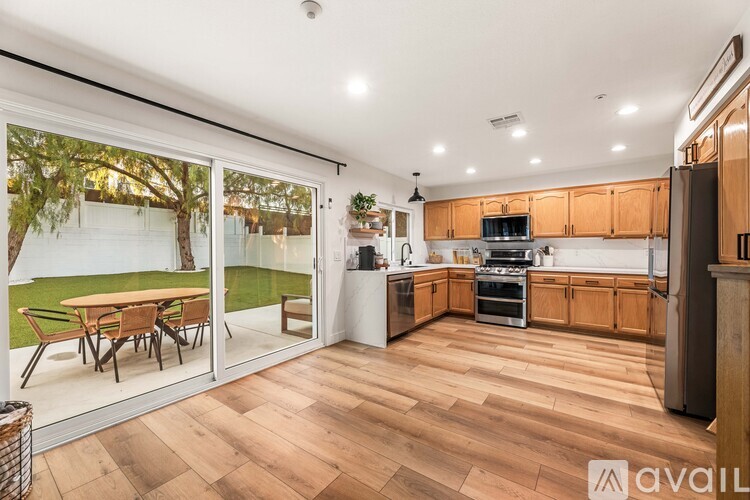 A kitchen with wooden floors and a dining table outside.