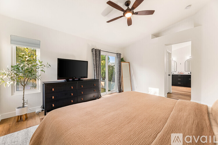 A bedroom with a large bed and a flat screen TV.