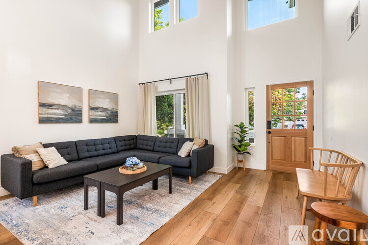 A living room with a black couch and a coffee table.