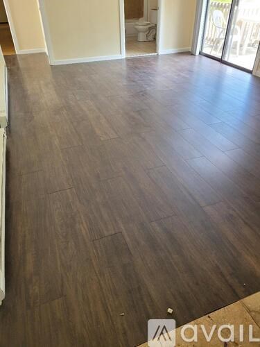 A room with wooden flooring and a white wall.