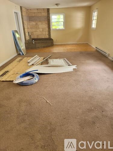 A room with a carpeted floor and a stone wall.