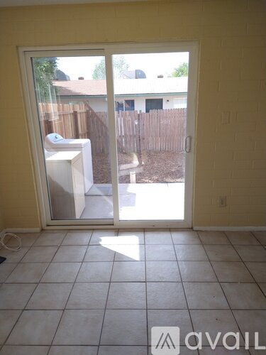 A room with a sliding glass door leading to a backyard.