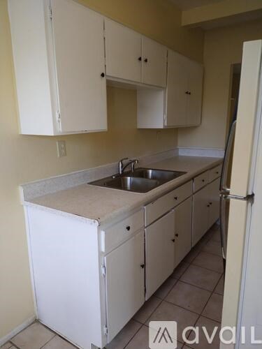 A kitchen with white cabinets and a sink.