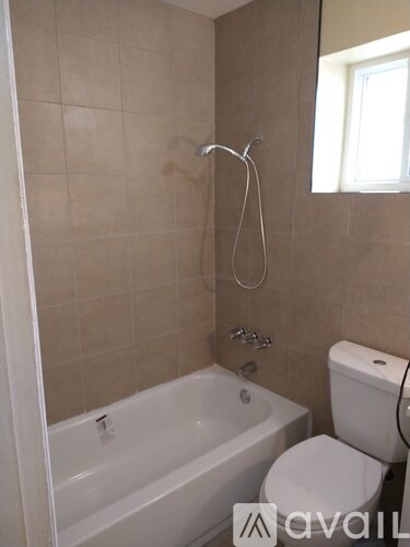 A bathroom with a white tub, toilet and sink.