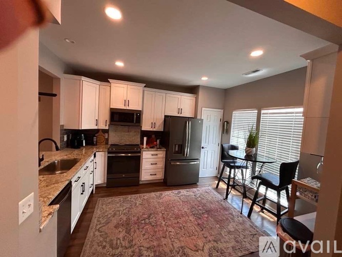 A kitchen with white cabinets and a granite countertop.