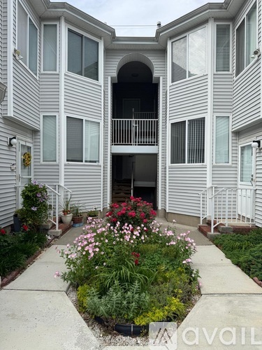 A building with a flower bed in front of it.
