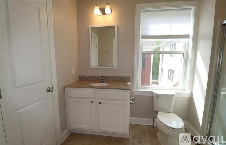 A white bathroom with a sink, toilet, and a mirror.