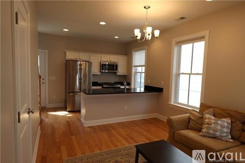 A kitchen with a refrigerator, microwave, and oven is visible.