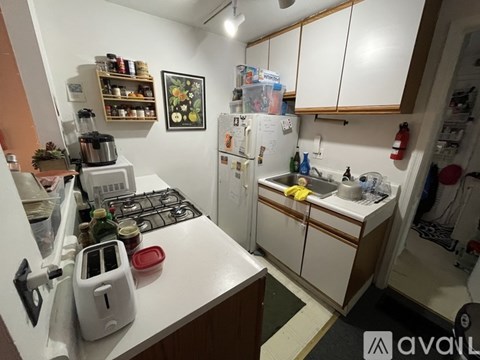 A kitchen with white cabinets and a white stove top oven.