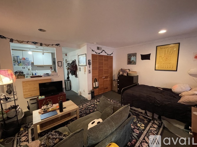 A living room with a couch, a bed, and a television.