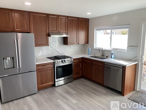 A kitchen with wooden cabinets and stainless steel appliances.