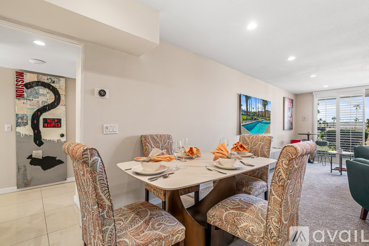 A dining room with a table set for four and chairs with a map of the world on the wall.