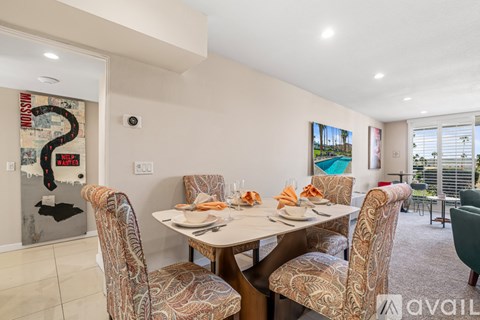 A dining room with a table set for four and chairs with a map of the world on the wall.