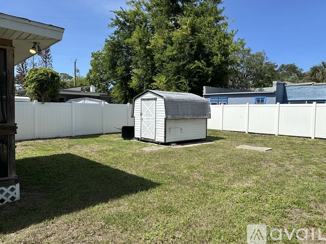 A shed sits in a grassy backyard.