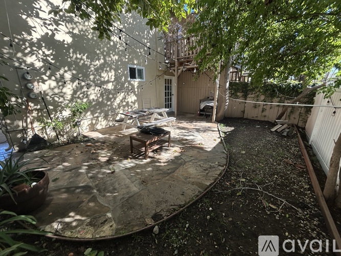A backyard with a table and chairs surrounded by trees.