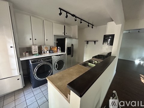 A kitchen with a white counter and a washing machine.