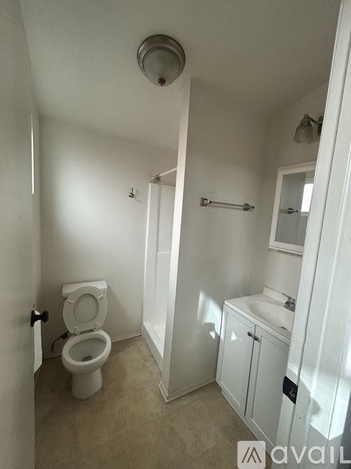 A bathroom with a toilet, sink, and mirror.