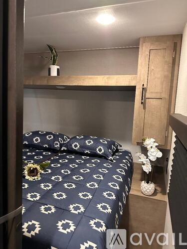 A bed with a blue and white patterned cover sits in a small room.