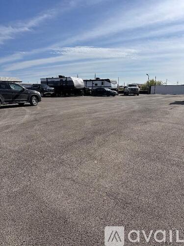 A parking lot with a black car and a white truck.